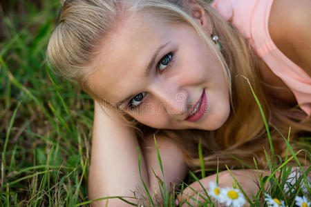 一个快乐的笑着的年轻女人躺在草地上