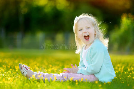 可爱的小女孩坐在草地上