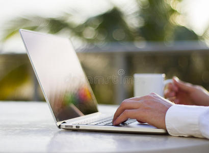 商人用笔记本电脑和一杯咖啡工作