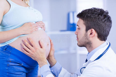 医生检查站立孕妇的胃