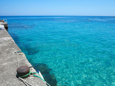 蓝色海景在阳光明媚的夏天，透明的水在码头