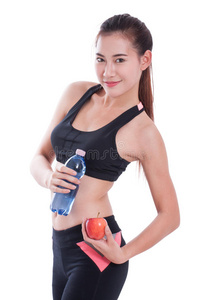 健身的年轻女人拿着一瓶水和一个苹果