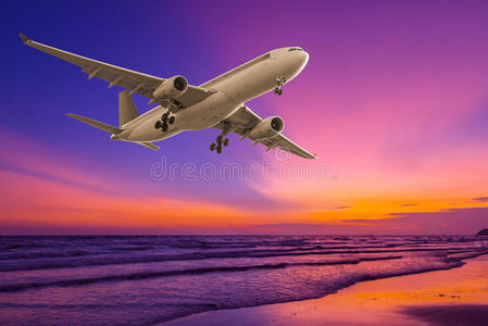日落时在海上飞行的商业飞机