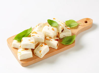 白牛轧糖与不同的坚果,木制的桌子上白色软牛轧糖的多维数据集白软牛