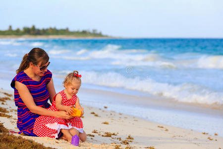 热带海滩上的母亲和小女儿