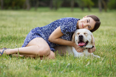在玩耍的狗一个女孩在草地上和一只狗玩耍. 训练狗照片
