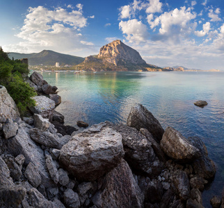 美丽的夏天日落在大海与山和石头