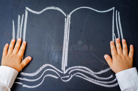 婴儿的手拿着一本书画在黑板上