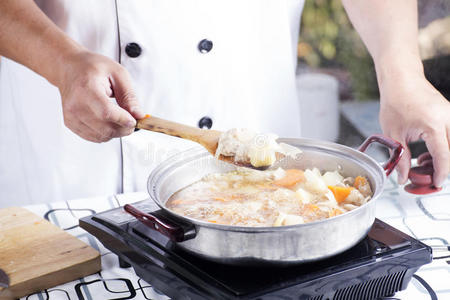 厨师在锅里炒猪肉片，煮日本菜