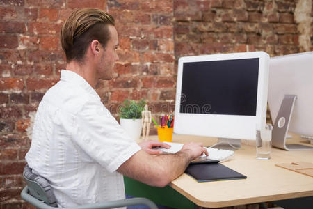 创意工人在办公桌上的笔记本电脑上打字