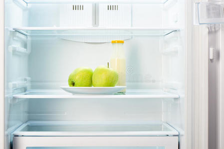 苹果在白色盘子上，冰箱里有一瓶酸奶