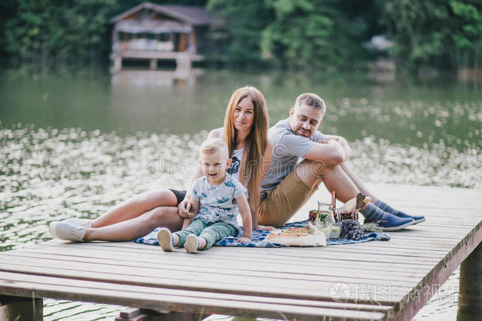 美丽的幸福家庭在湖边野餐