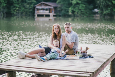 美丽的幸福家庭在湖边野餐