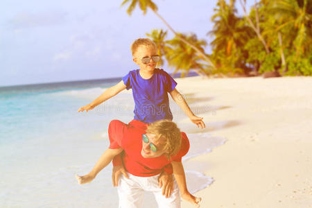 爸爸和小儿子在夏天的海滩上玩耍