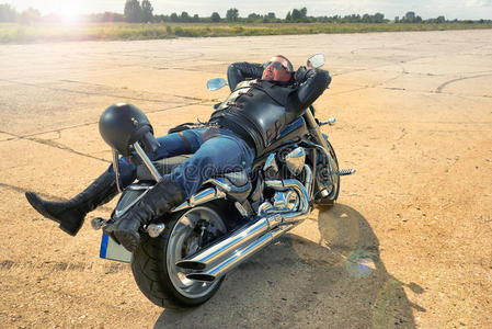 骑摩托车的人躺在摩托车上。