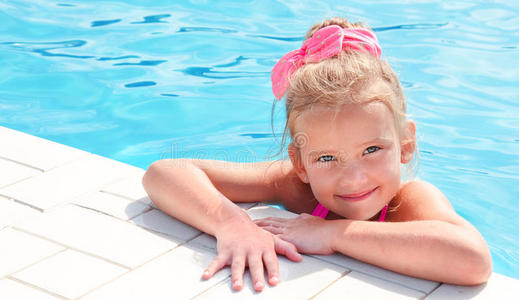 游泳池里微笑的小女孩