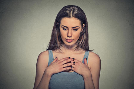 紧张地尖叫的女人美丽的女人,害羞,紧张地玩着,双手向下看照片