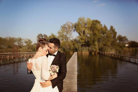 新娘夫妇在湖边的木桥上