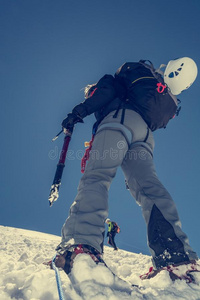 女性登山者爬上雪坡。