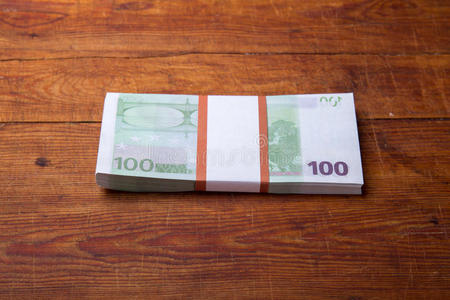 木材背景上100欧元纸币的特写