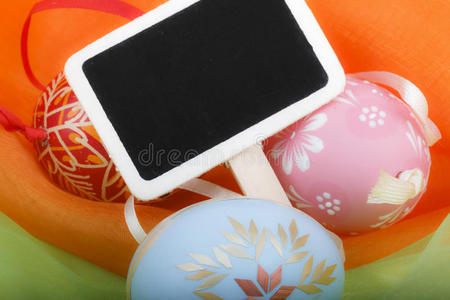 复活节彩蛋的特写和彩色天鹅绒上的黑板