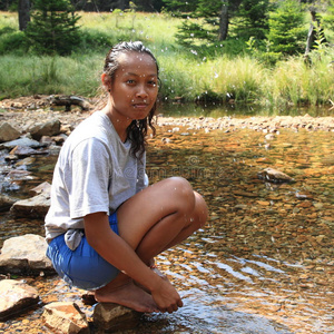 溪流边小溪边的赤脚女孩照片