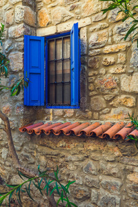 一座古老的石头房子里的蓝色窗户