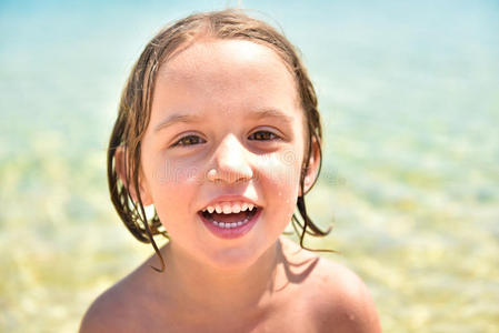 海滩上的女孩微笑着看着相机。