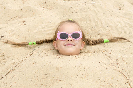 五岁的女孩戴着眼镜在海滩上