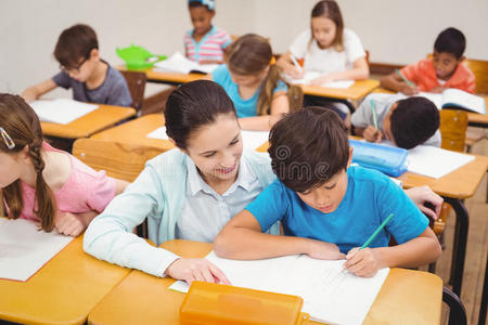 老师在课堂上帮助一个小男孩照片