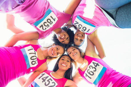 五个微笑的跑步者支持乳腺癌马拉松
