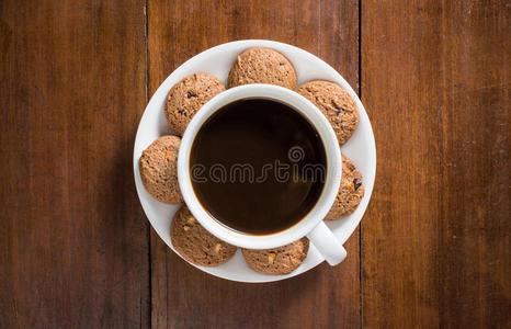 咖啡杯和美味的饼干在木制背景，顶部视图