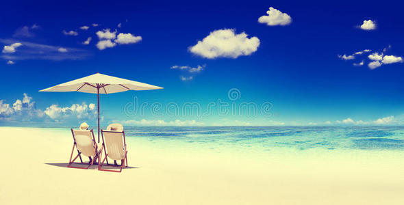 一对夫妇坐在海滩避暑的概念