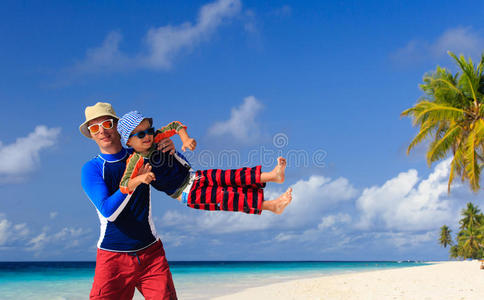 父子在热带海滩玩耍