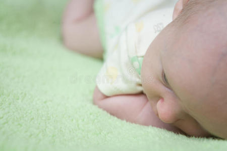 婴儿躺在绿色的毯子上