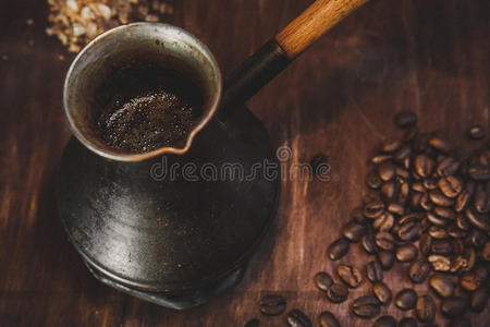 木制背景上的咖啡豆和金属勺