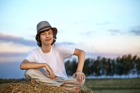 男孩在田里的干草堆里