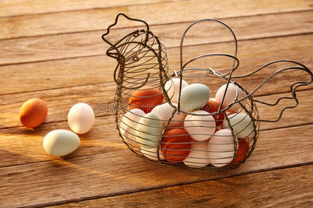 鸡蛋在老式母鸡形状的篮子在木头上