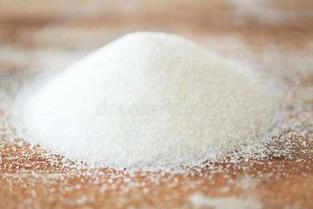 把白糖堆放在木桌上照片
