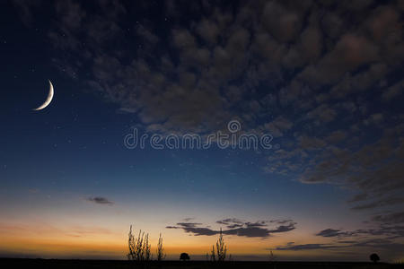 美丽的夜空，月亮，夜晚背景上美丽的云。 月亮逐渐消失的新月。 斋月背景