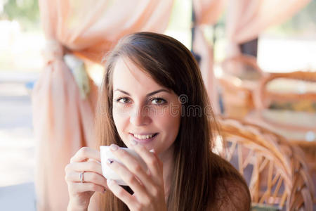 一位带着一杯咖啡的漂亮女人的特写肖像