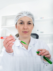 实验室里有玻璃设备的女性研究员。