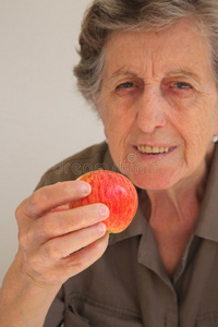 老妇人手里的一个粉红色的红苹果