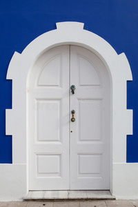 蓝色墙上漂亮的白色门