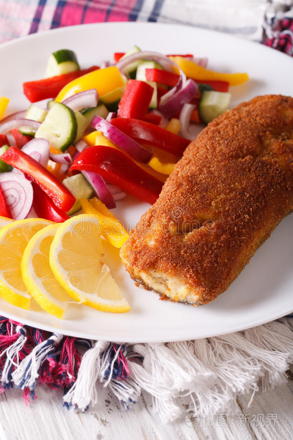 油炸鱼和新鲜蔬菜沙拉在盘子特写。 维特
