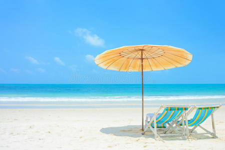 蓝色的大海和白色的沙滩，有沙滩椅和阳伞