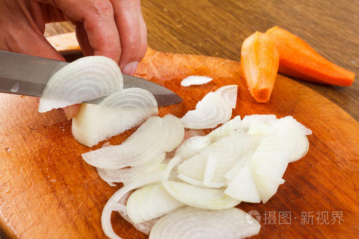 切割板上切葱切多汁的洋葱在砧板上切洋葱在砧板上切洋葱和胡萝卜厨