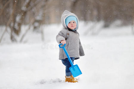 漂亮的蹒跚学步的男孩玩雪