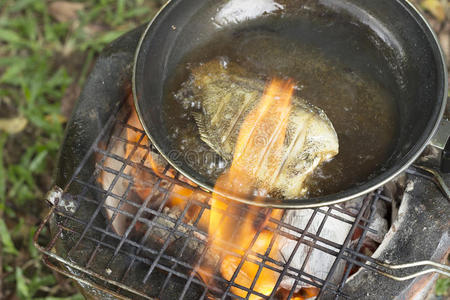 在森林里露营时做饭炸鱼。