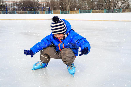 可爱的小男孩在冬天学滑冰